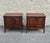 Pair of mid-century walnut nightstands with a rectilinear case set on tapered legs. Each cabinet features two front doors.