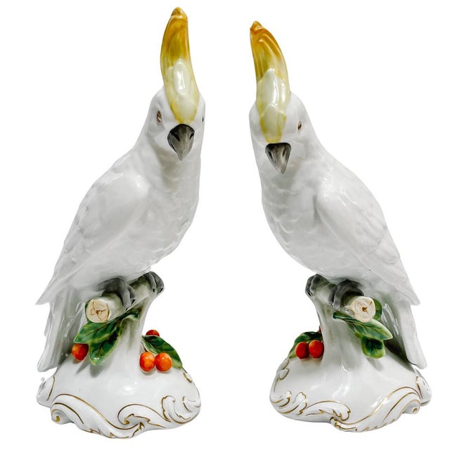 Pair of vintage porcelain Sulphur-crested cockatoo parrots by Vista Alegre Portugal. They are each perched on a cherry...