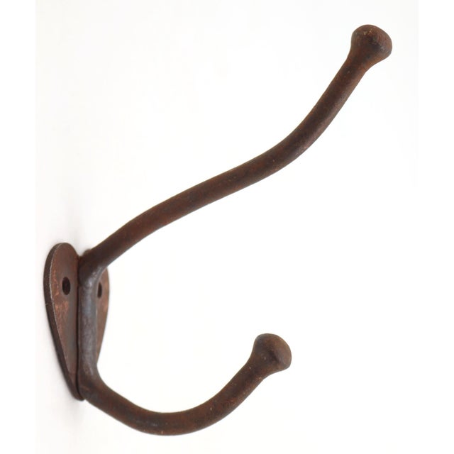 Vintage cast iron double arm wall hook with a rusted finish. The original mounting screws are not available. Good...