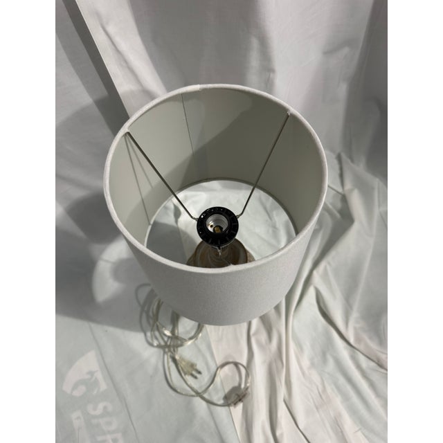 Oneach Retro Table Lamp features a charmingly distressed, carved floral resin base paired with a simple white fabric drum...