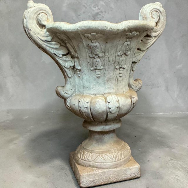 This is a pair of late 20th century neo-classical style cast stone planters. They have a timeless urn form and are in very...