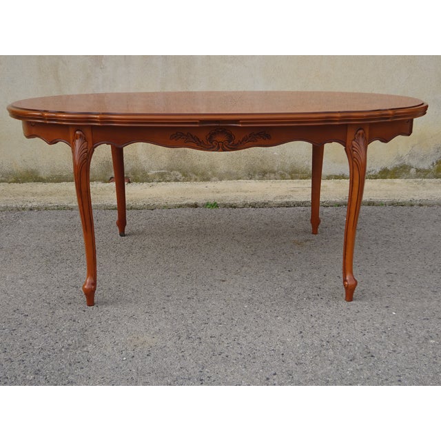 Large oval table seating 6 to 12 people thanks to the integrated extensions stored beneath the tabletop. Cherry-stained...