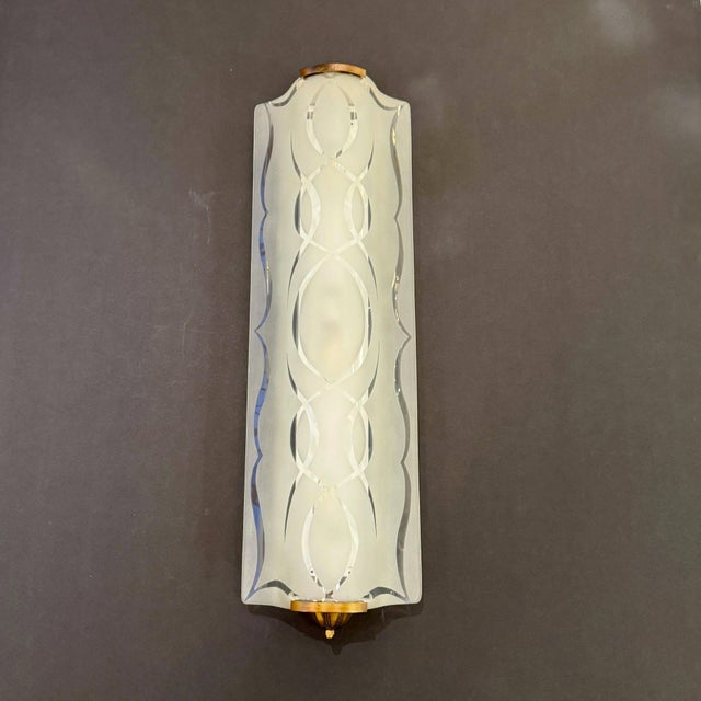 A pair of Art Moderne wall sconces from France circa 1940. Each frosted glass shade has the clear wavy pattern associated...