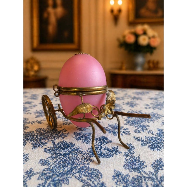Beautiful antique French pink opaline egg-form casket set in an unusual brass carriage stand. This charming decorative...