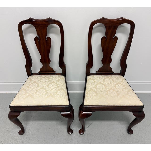 A pair of Queen Anne style dining side chairs by Henkel Harris of Winchester, Virginia, USA. Solid mahogany, carved crest...