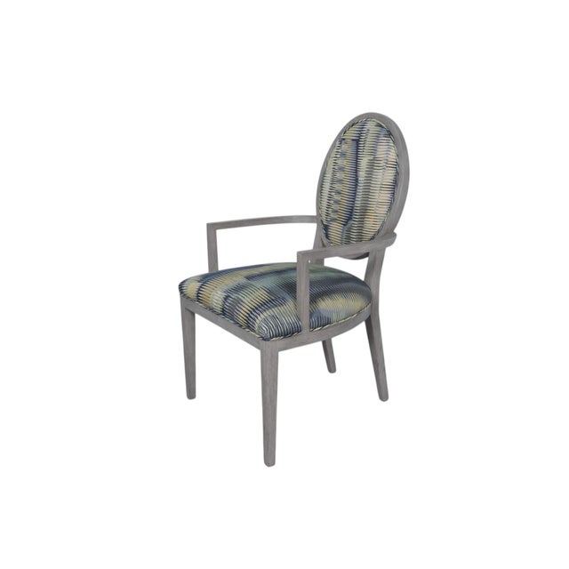 A contemporary oval back arm chair attributed to Basset Furniture. A simply carved solid oak frame finished in gray, gives...