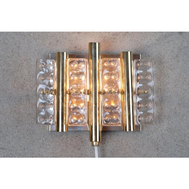 - Beautiful brass/gold colored wall sconce - With thick pressed glass pieces in an abstract pattern - Danish design from...