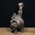 This charming vintage sculpture depicts a playful scene of two young boys interacting with a large elephant, a traditional...