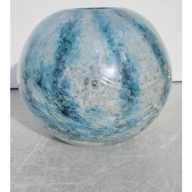Blue, white, and bubbles swirling around the ball vase, moving deep inside the thick wall and bubbling up inside the vase....