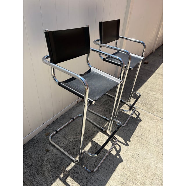 These appear to be a pair of vintage modernist chrome bar stools/director-style chairs, likely inspired by Bauhaus or...