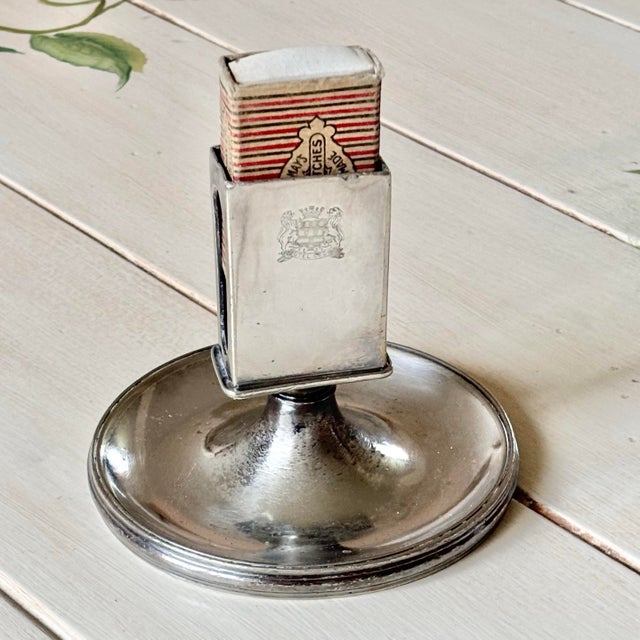 Magnificent 20th-century silver-plated pedestal matchbox holder from Hotel Celine featuring a stately engraved shield...
