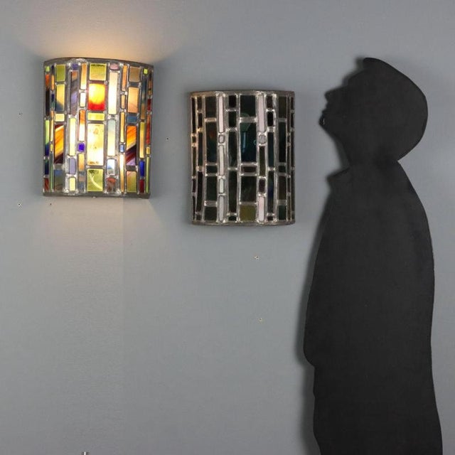 Pair of wall lamps featuring a metal structure supporting an elegant diffuser made with stained glass arranged in a mosaic...