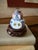 This charming miniature porcelain vessel features hand-decorated blue, red, and white motifs accented by a central...