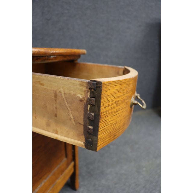 Late 19th-century Victorian quarter sawn oak commode with a single curved-front drawer over a paneled cabinet door. The...
