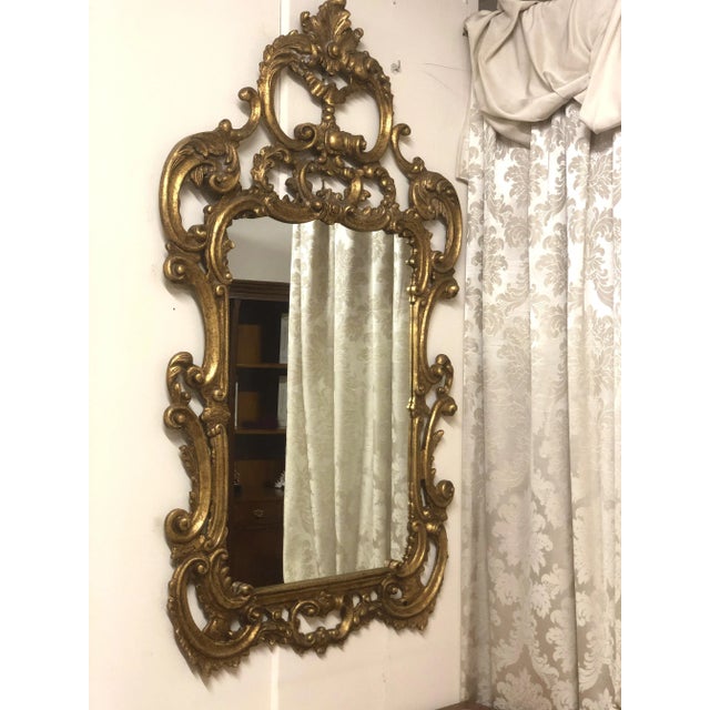 Baroque style mirror of high Venetian craftsmanship in carved wood and decorated in gold leaf. Unique piece of high...