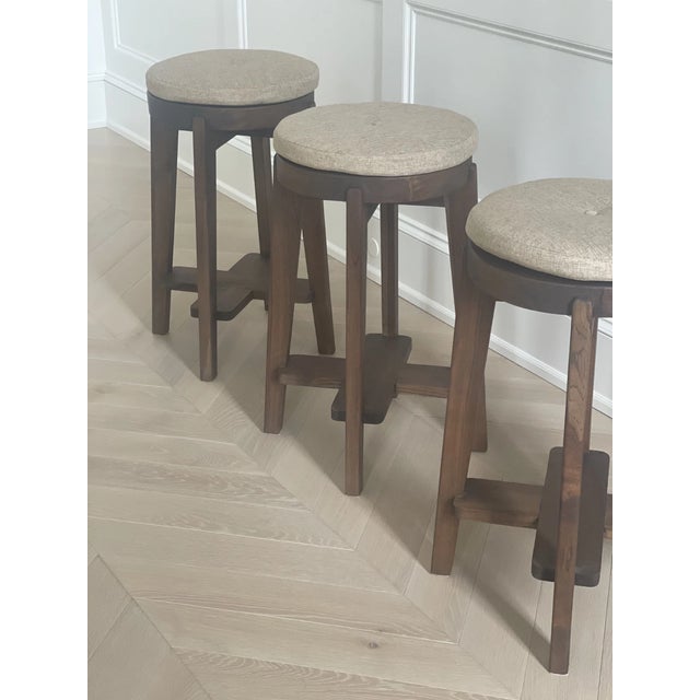 Elevate your space with this set of 3 Pierre Jeanneret-style teak stools, inspired by the iconic mid-century Chandigarh...