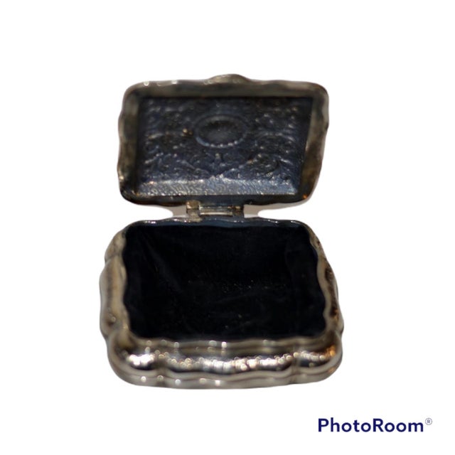 A small silverplated jewelry box . Polished finish outside and lined with black velvet. The lid is hinged. with engraving...