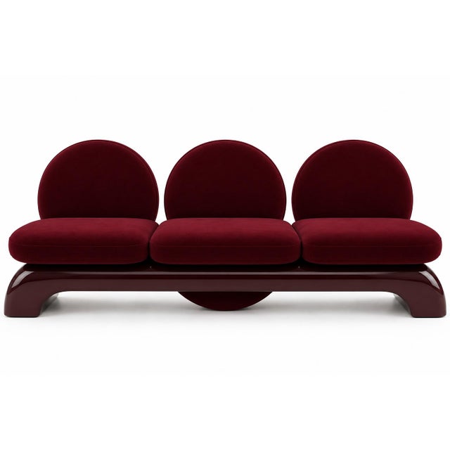 A three-seat sofa by Alexandre Ligios, each round velvet seat-and-backrest disc rising from a continuous bordeaux...