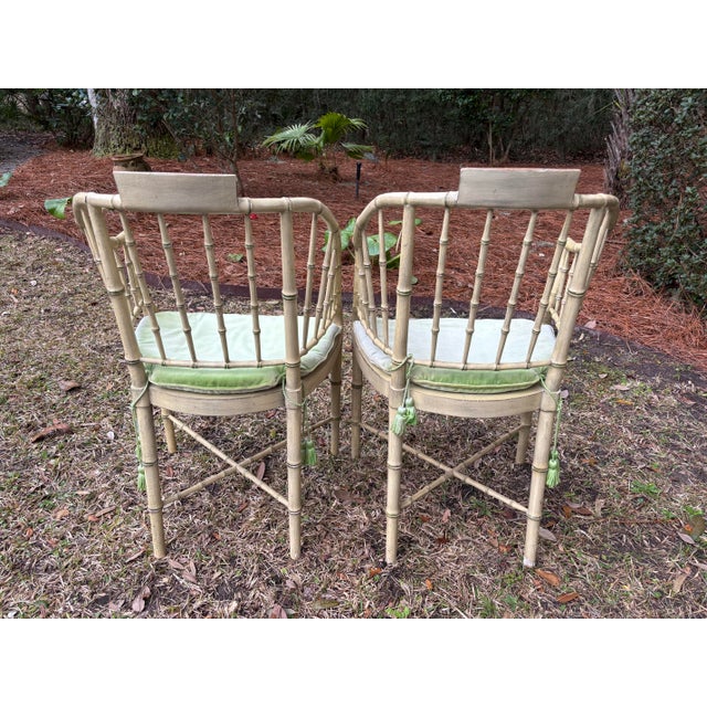 Pair of vintage faux bamboo painted armchairs produced by Baker circa 1960. The original finish shows wear as per the...