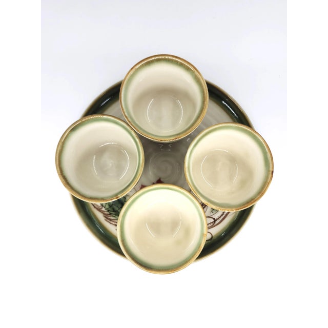 Delicately hand-painted with lotus flowers and winding vines, this Bat Trang ceramic tea set reflects Vietnam’s centuries-...