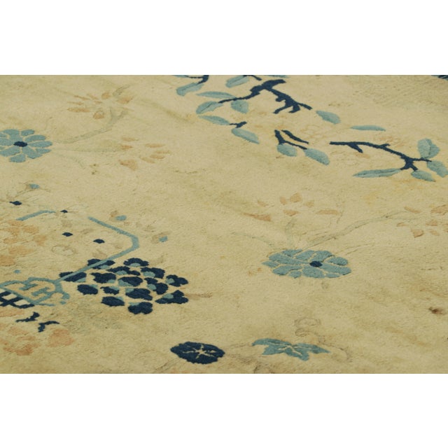 Made with hand-knotted wool in China circa 1900-1910, this 10x15 antique Chinese rug is a rare Peking rug of exceptional...