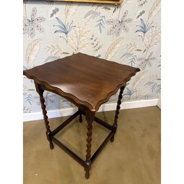 Such a lovely piece of history, this side table features distinctive barley twist legs and a delicate scalloped top. This...