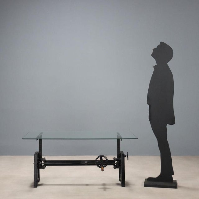 Glass coffee table, iron base with movement mechanism for adjusting the height of the top. Italy, 20th century. This piece...