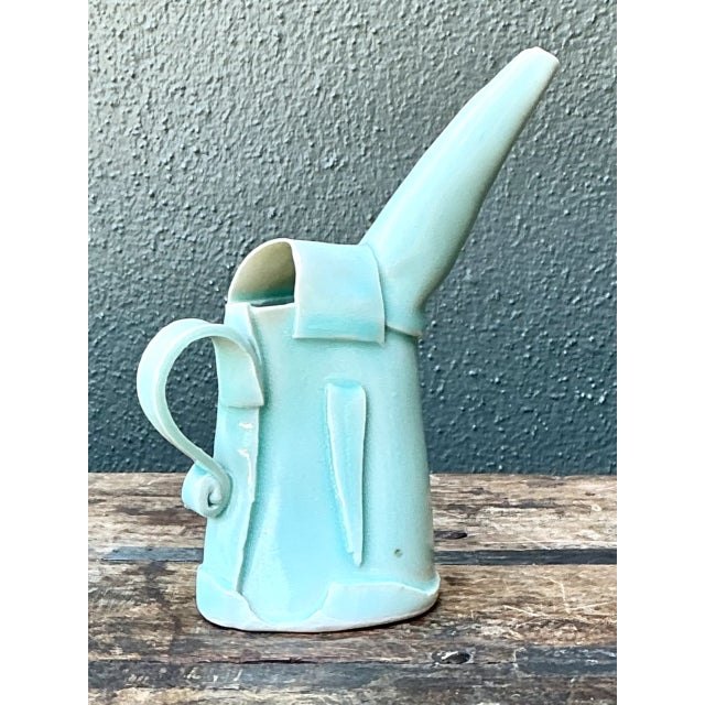 This vintage ceramic pitcher brings an appealing aqua hue and an abstract, mid-20th-century sensibility to a room. Its...