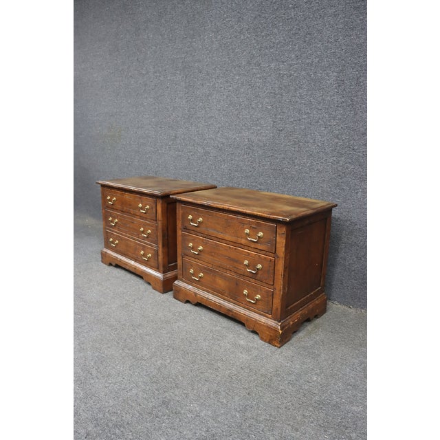 A pair of cherry wood nightstands from the Melrose Collection by Guy Chaddock & Co. Each features three dovetailed drawers...