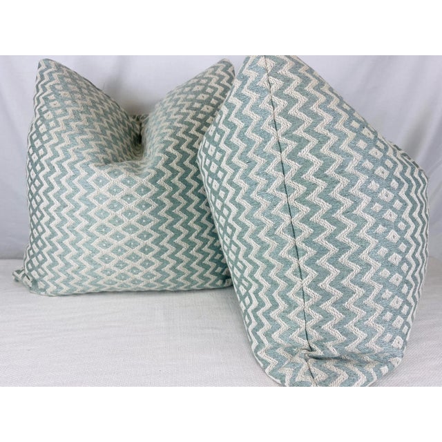 Custom pair of 22" pillows covered in a woven ikat stripe fabric in aqua and cream. These pillows have tapered corners to...