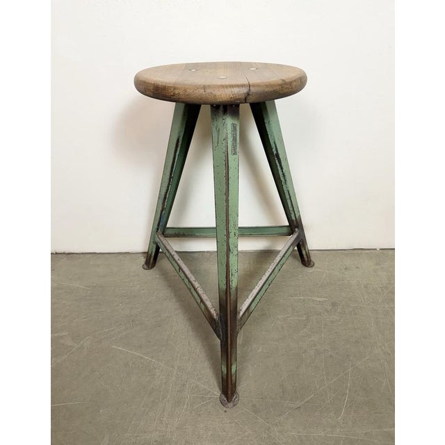 Vintage Industrial factory stool made in former Czechoslovakia during the 1960s It features a wooden seat and a green iron...