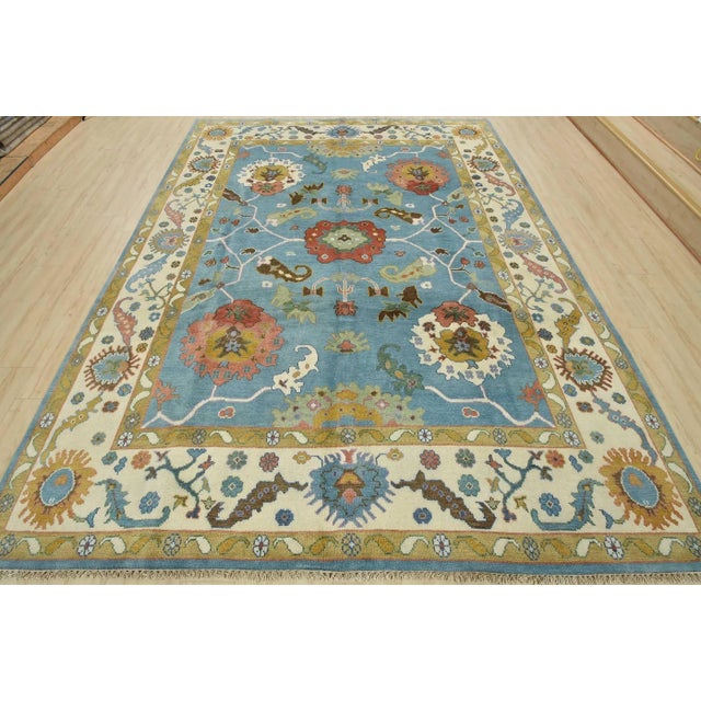 This traditional Oushak rug is hand-knotted with an all-wool pile on a cotton foundation. This rug is new and in excellent...