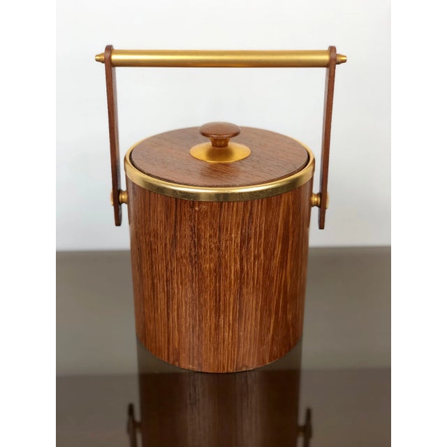 Italian ice bucket in teak and gold metal details, circa 1960s. The "Made in Italy" engraving is visible on the bottom, as...