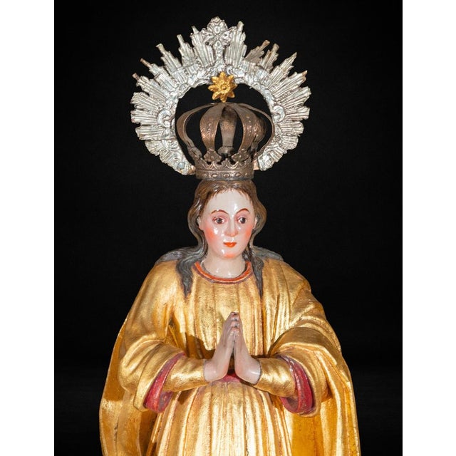 A striking Colonial Spanish American sculpture of the Immaculate Conception, carved in wood and richly gilded, dating from...