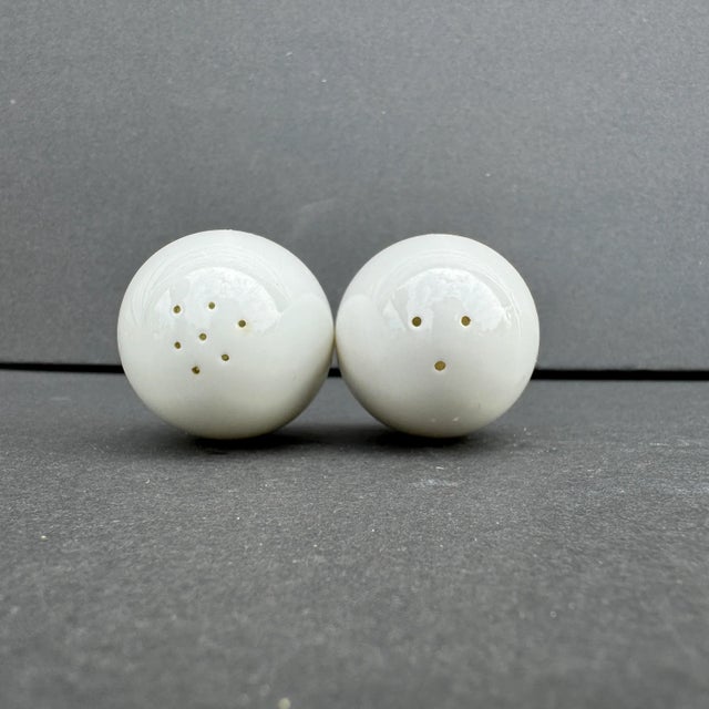 This charming set of vintage bone china salt and pepper shakers is designed in the whimsical shape of eggs. Each shaker is...