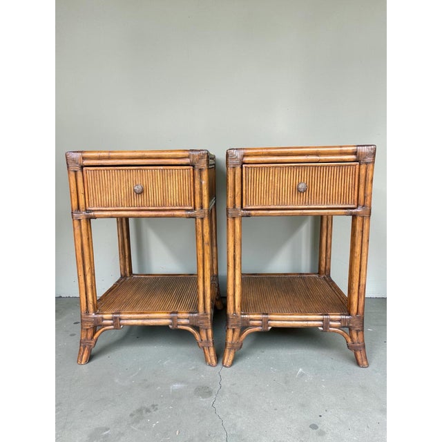 Pair of Tommy Bahama Home Del Sol nightstands from the Bali Hai collection. Crafted in pencil rattan with leather-wrapped...