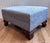 A vintage ottoman featuring new upholstery in a soft, tone-on-tone jacquard with a subtle floral motif in pale blue. The...