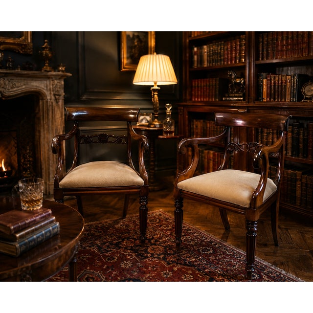 An elegant and highly decorative pair of English mahogany armchairs dating from the transition between the late Regency...