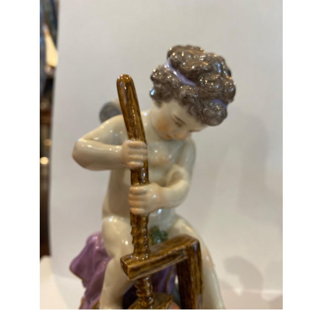 19th Century Meissen porcelain figure modeled to show the young putti with a cheese press, sat on a naturalistic rocky...