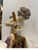 19th Century Meissen porcelain figure modeled to show the young putti with a cheese press, sat on a naturalistic rocky...