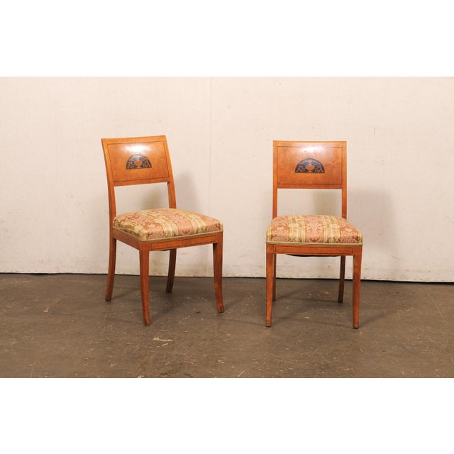 A Swedish set of four curly birch side chairs, with upholstered seats, from the first half of the 19th century. These...