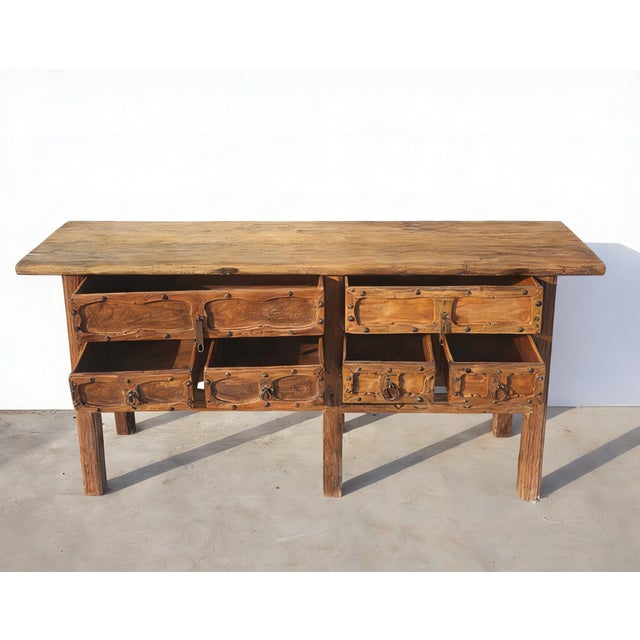This early 19th century sideboard is handmade using sturdy elm and features a natural, honey toned finish. It is designed...