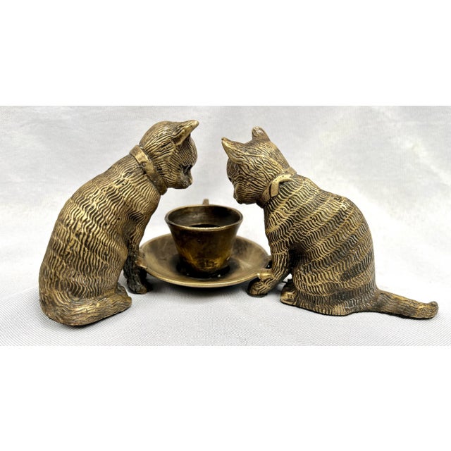 Vintage cast bronze sculpture of two cats sitting and peering into a teacup. The detailed texture and personality of the...