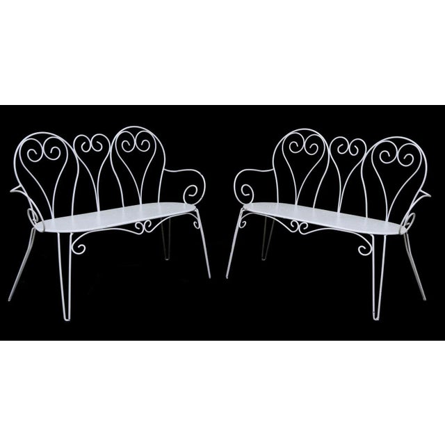 A pair of vintage French painted iron garden benches, mid 20th c., having scrolled wrought iron back and armrests, over...