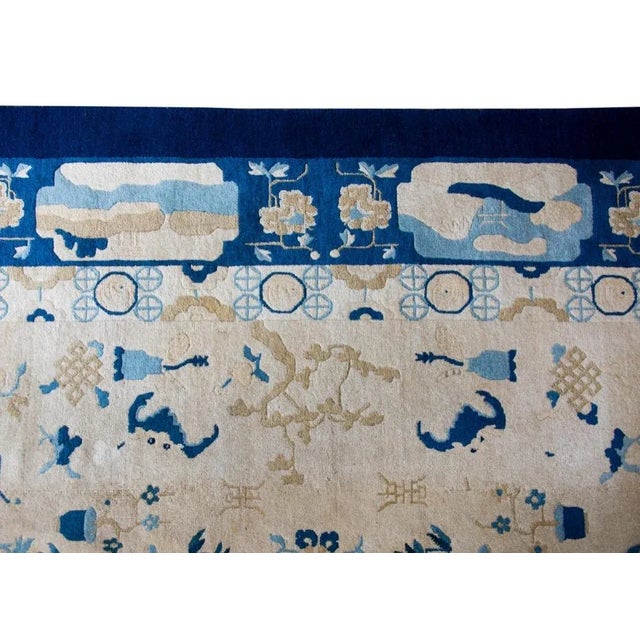 A stunning late 19th century Chinese Peking rug with a champagne colored field covered with pattern of auspicious flowers,...