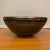 A dramatic large-scale studio pottery bowl, wheel-thrown in stoneware and richly glazed in earth tones, dating to the...
