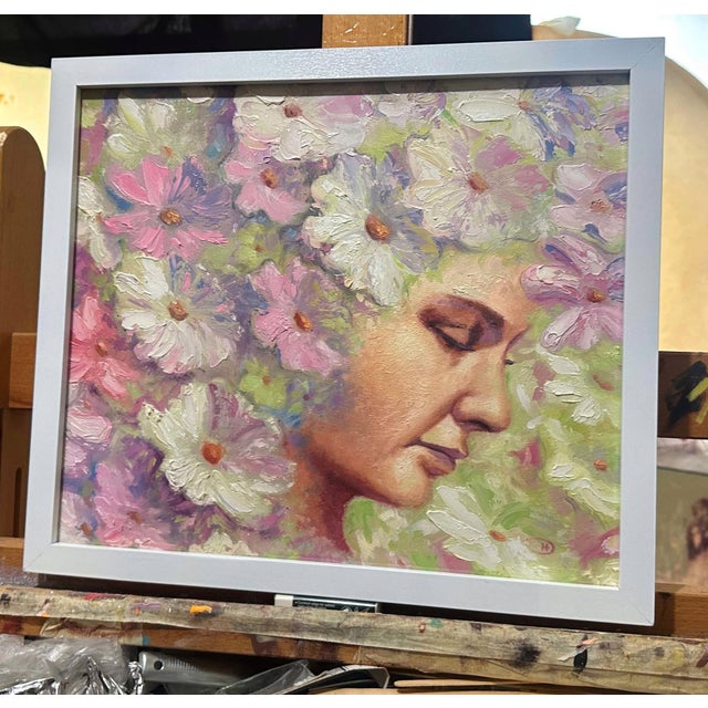 This oil on board painting features a serene female figure partially enveloped by a vibrant array of flowers, creating a...