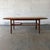 A Danish modern teak coffee table dating to the 1960s, with a long rectangular top, softly shaped edges, and a lower...