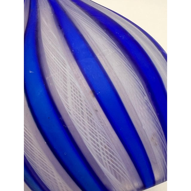 This vintage hand blown vase is eye-catching with its cobalt blue and latticework stripes. The lattice technique, called...