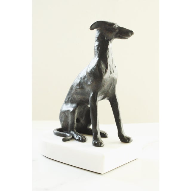 Bronze style Whippet dog presented on a plinth carved marble base. Every aspect of this sculpture is a testament to the...